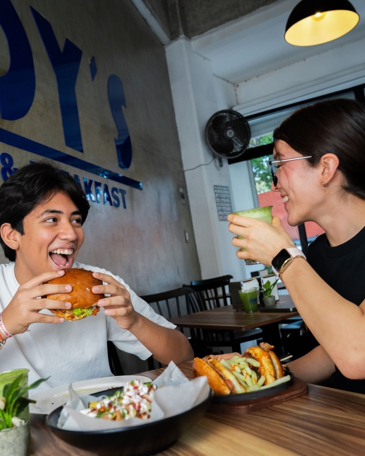 Clientes disfrutando burgers y bebidas en Lody's
